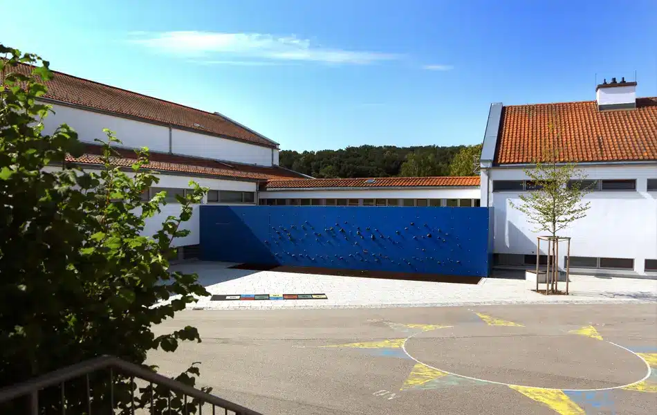 Schulgebäude der Grundschule Zeitlarn mit Pausenhof und Kletterwand.
