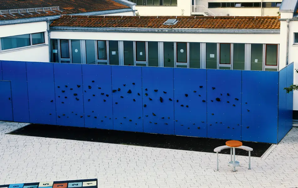 Blaue Kletterwand im Außenbereich der Grundschule Zeitlarn.