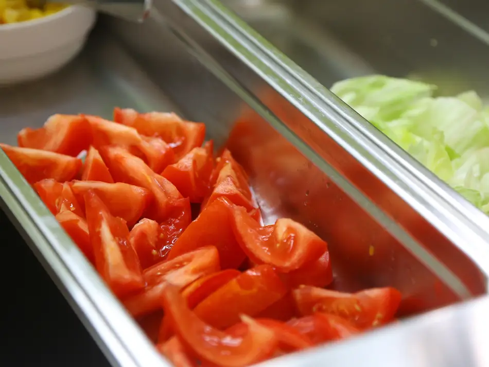 Aufgeschnittene Tomaten in der Mensa Essensausgabe.