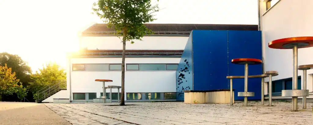 Pausenhof der Grundschule Zeitlarn mit Sitzgelegnheiten und Kletterwand.