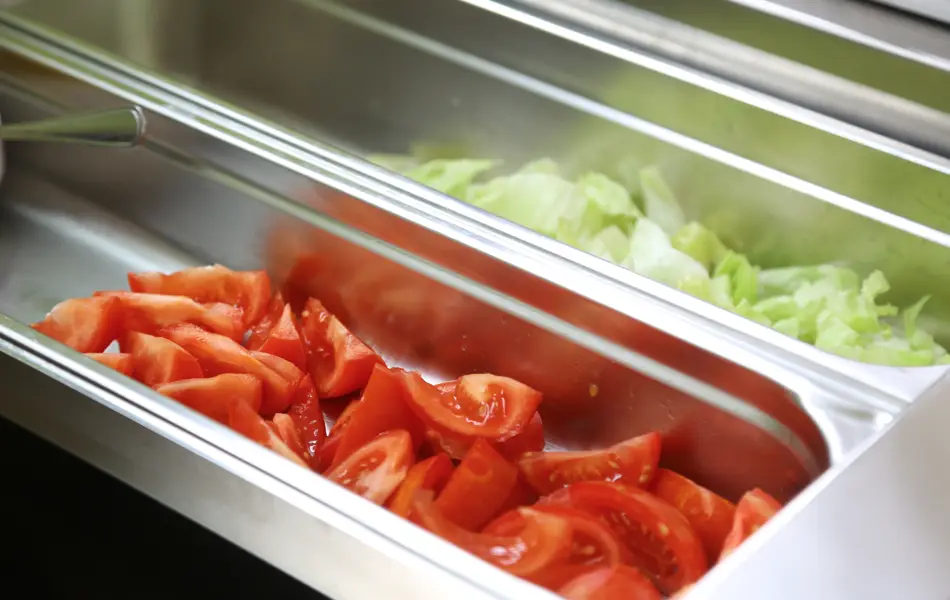 Frisch aufgeschnittene Tomaten und Salat im Salatbuffet.